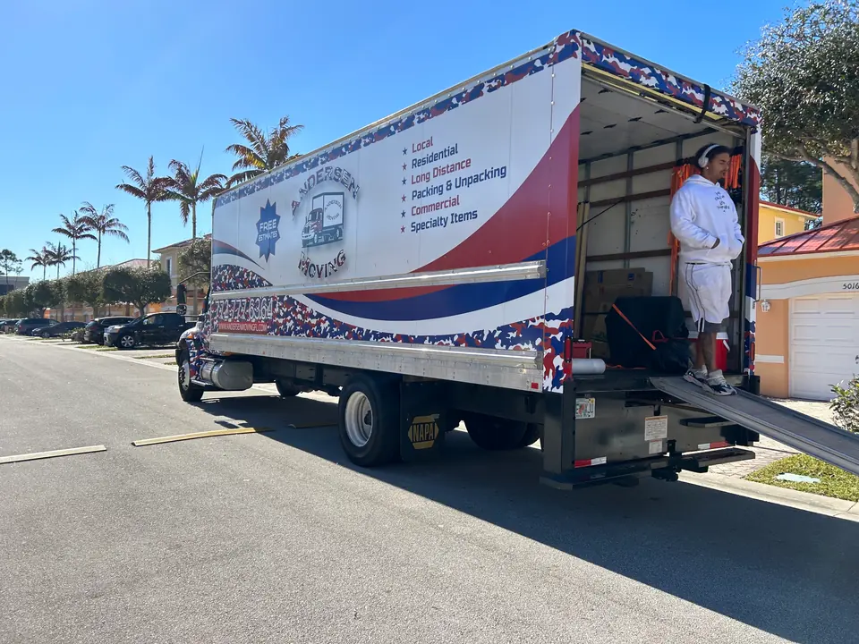 Andersen Moving crew loading a wrapped truck on a Port St. Lucie street